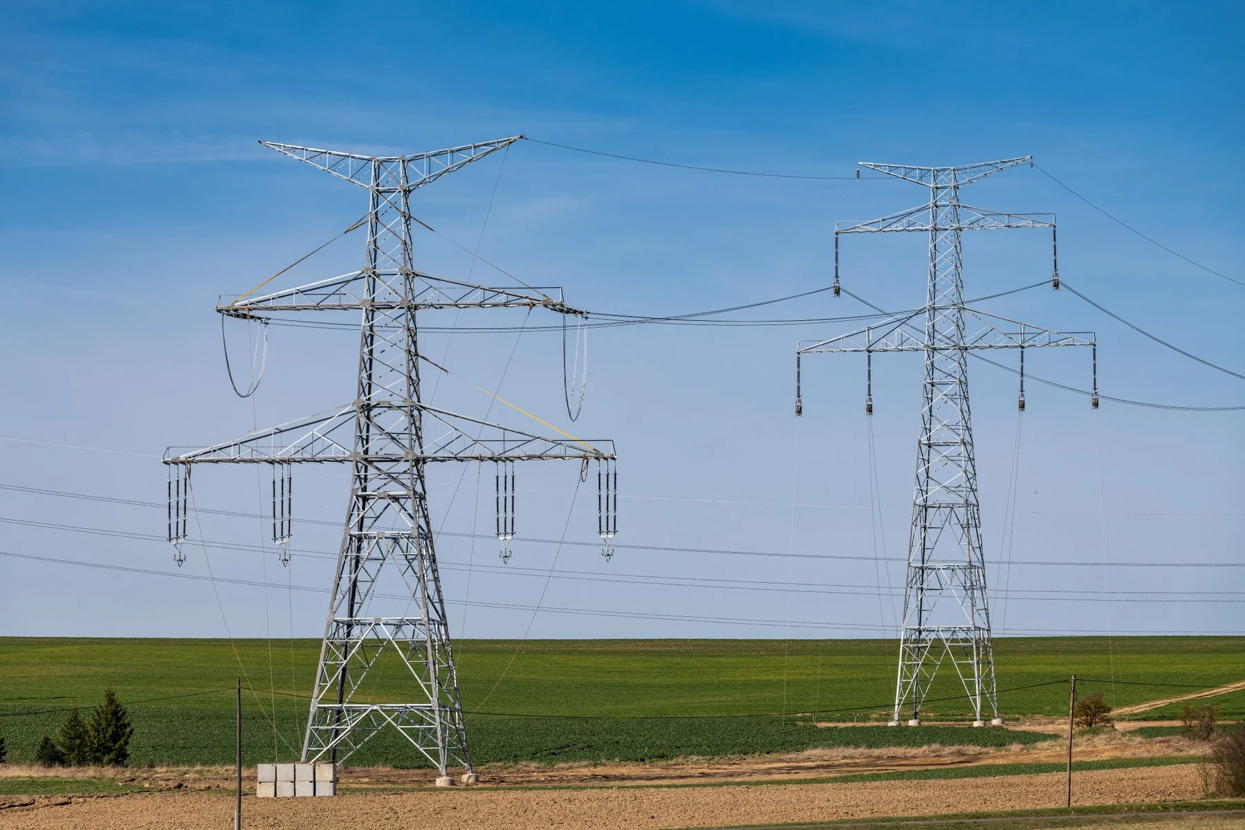 Representative high-voltage lattice transmission towers and overhead conductors