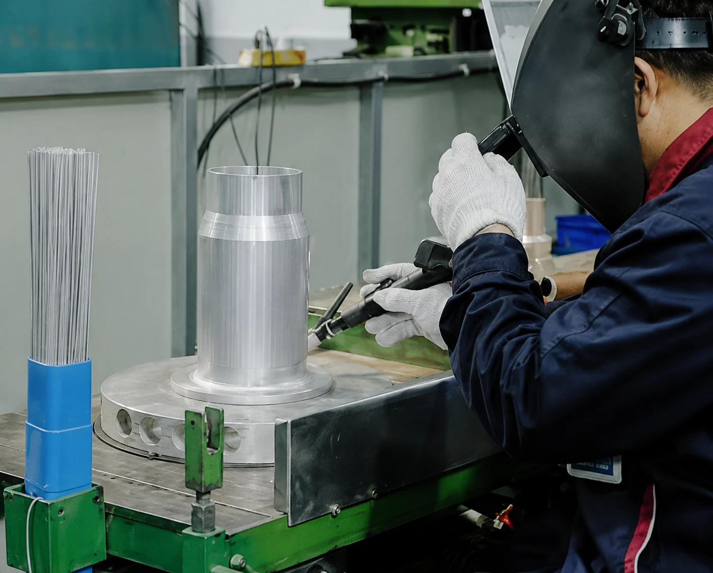 Worker welding and assembling an overhead line component